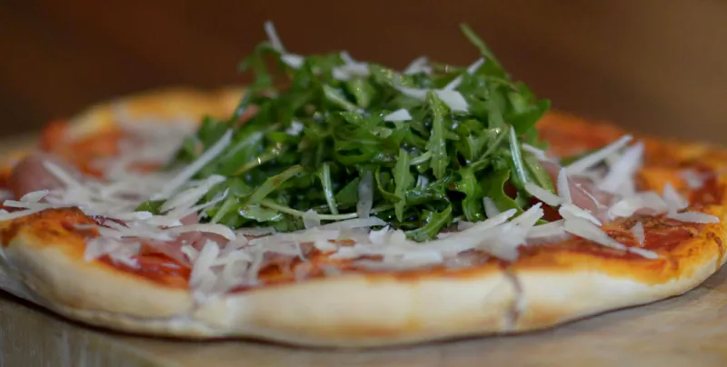 Pizza mit Rucola und Parmesan